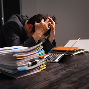Overwhelmed by paperwork at desk
