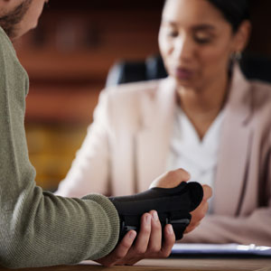 A man with a wrist brace consults with a legal professional about a personal injury